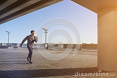 Young fit man running at outdoors, autumn , attractive dark skinned runner jogging fast, sport concept Stock Photo