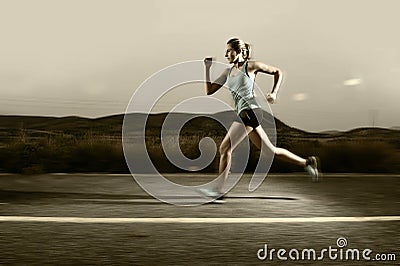 Young fit sport woman running outdoors on asphalt road in mountain landscape and dramatic light set for advertising Stock Photo