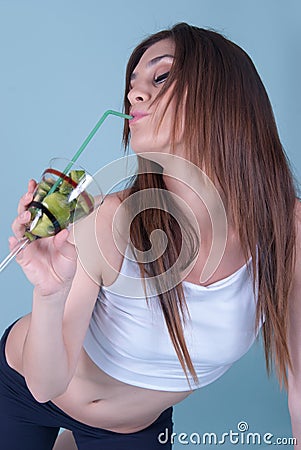 Young fit woman holding a glass with kiwi pieces Stock Photo