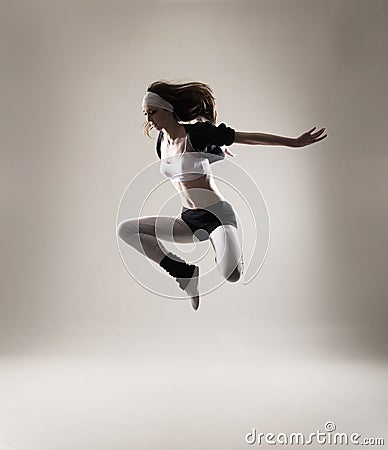 A young and fit woman jumping in sporty clothes Stock Photo