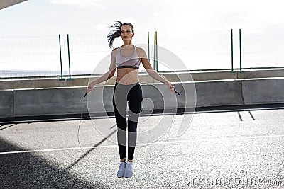 Young fit woman skipping with a jump rope in the city Stock Photo