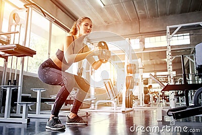 young fitness girl doing exercise squat with weight barbell plat Stock Photo