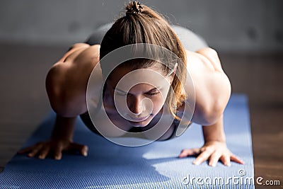 Young fitness woman doing chaturanga dandasana pose Stock Photo