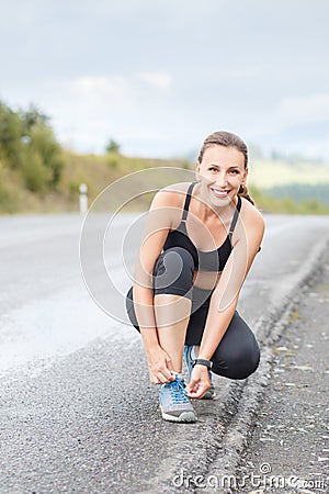 Young fitness woman lace up her trainers before jog Stock Photo