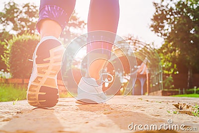 Young fitness woman legs walking in the morning for warm up body for jogging and exercise at outdoor public park Stock Photo