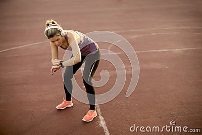 Young fitness woman looking at her smart watch while taking a br Stock Photo