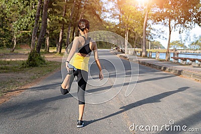 Young fitness woman runner stretching legs before run on city, Young fitness sport woman running on the road in the morning Stock Photo