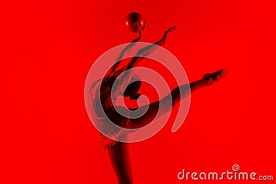 Young flexible female gymnast isolated on red studio background Stock Photo