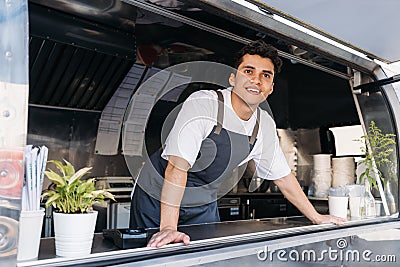 Young food truck owner in apron. Salesman looking away Stock Photo