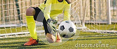 Young Football Goalkeeper Catching Soccer Ball. Soccer Goalie in Action Saving Ball in a Goal Stock Photo