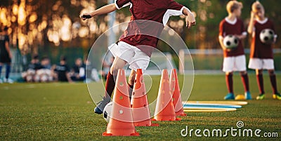 Young football players training on pitch. Soccer slalom cone drill. Stock Photo