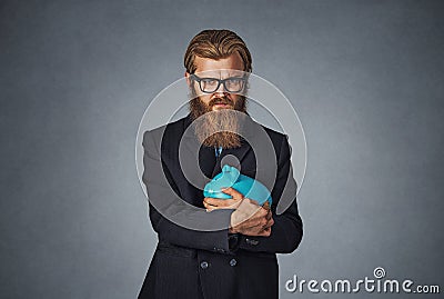 Man holding with greedy hand gesture the piggy bank Stock Photo