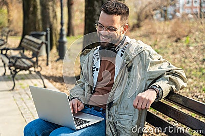 Young freelance business hipster man is work on new project outside on laptop computer. Businessperson working and telecommuting Stock Photo