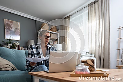 Young freelance business woman working at home on laptop as product strategy expert. Female expatriate remote work on internet on Stock Photo