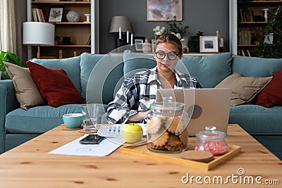 Young freelance business woman working at home on laptop as product strategy expert. Female expatriate remote work on internet on Stock Photo