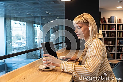 Young freelancer business woman or student, expat or vlogger preparing for work and internet online video call from bookstore or Stock Photo