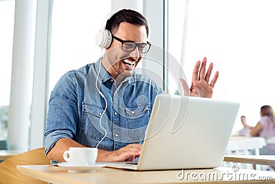 Young freelancer listening music and working at the coffeehouse Stock Photo