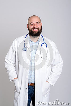 Young friendly and bearded doctor in white coat Stock Photo