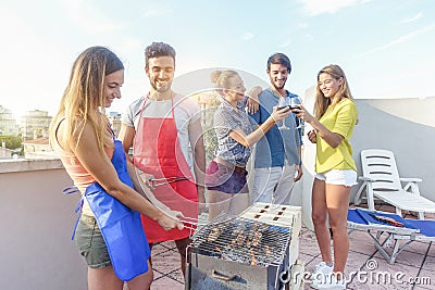 Young friends cooking meat at dinner barbecue party and drinking red wine - Happy people grilling and having fun at bbq meal at Stock Photo