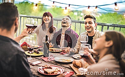 Young friends having fun drinking red wine at balcony penthouse dinner party - Happy people eating bbq food at fancy alternative Stock Photo