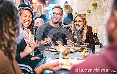 Young friends having fun drinking white wine at street food festival - Happy people eating local plates at open air restaurant Stock Photo