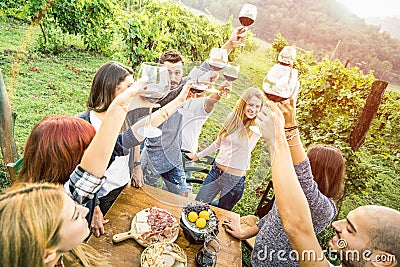 Young friends having fun outdoors drinking red wine at vineyard winery Stock Photo