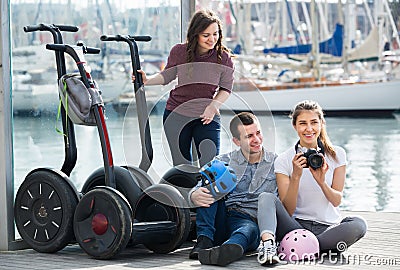 Young friends posing near segways on shore Stock Photo