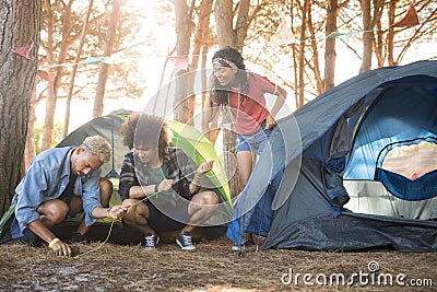 Young friends setting up tent at forest Stock Photo