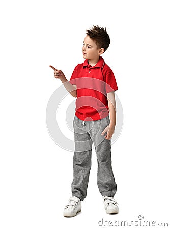 Young full body boy kid in red polo t-shirt standing pointing one finger at the corner isolated on white Stock Photo