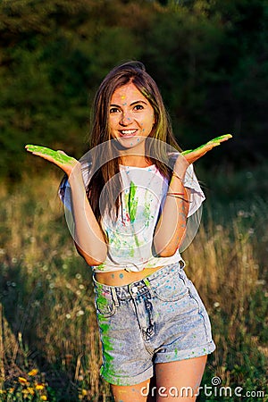 A young funny girl smeared with paint spreads her hands apart Stock Photo