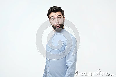 Young funny hispanic man with black beard is shocked and suprised. Stock Photo