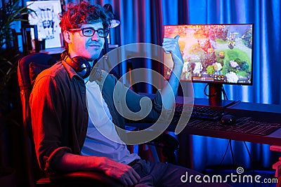Young gaming streamer looking at camera against Moba screen. Gusher. Stock Photo