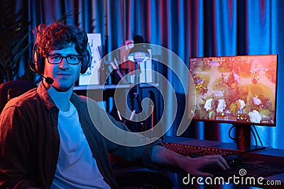 Young gaming streamer looking at camera against Moba screen. Gusher. Stock Photo