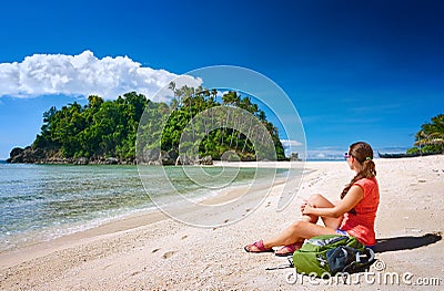 Young gerl with backpack relaxing on coast and looking to a isla Stock Photo