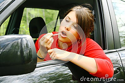 Young girl applying lipstick Stock Photo