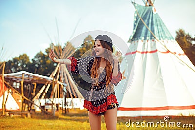 Young girl beautiful tourist take photo selfie, video communication and smiling, kiss on the background teepee / tipi- native indi Stock Photo