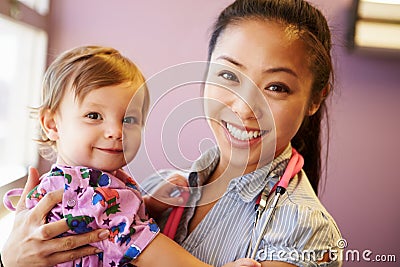 Young Girl Being Held By Female Pediatric Doctor Stock Photo