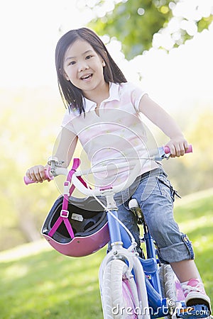 Young girl on bicycle outdoors smiling Stock Photo