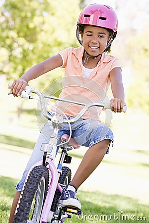 Young girl on bicycle outdoors smiling Stock Photo