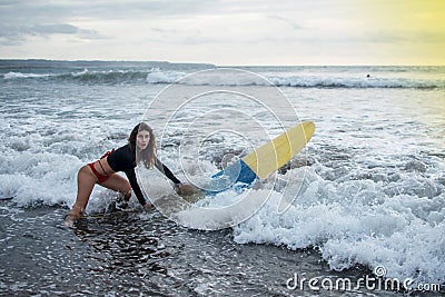 Young girl in bikini - surfer with white lines mask on her pretty face surf board dive underwater with fun under big Stock Photo