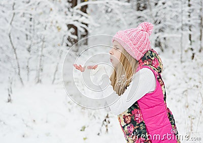 Young girl blows off snowflakes from palm Stock Photo