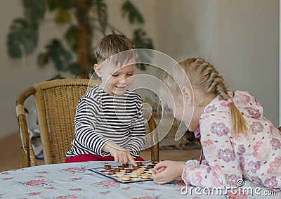 Young girl and boy playing checkers together Stock Photo