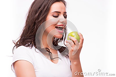 Young girl with brances eat apple. Female teeth with dental braces and apple. Stock Photo