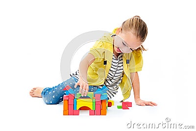 Young girl building a castle with wooden toy block. Child play therapy concept on white background. Stock Photo