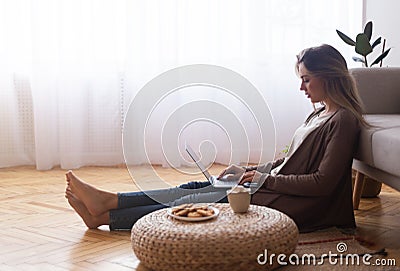 Young girl chatting with friends online, resting at home Stock Photo