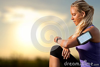 Young girl checking workout on smart watch at sunset. Stock Photo