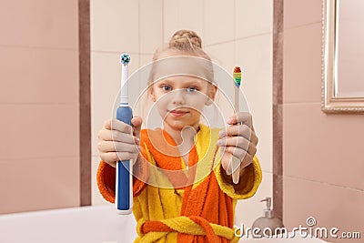 Young girl choice toothbrush. Bamboo or electric tooth Stock Photo