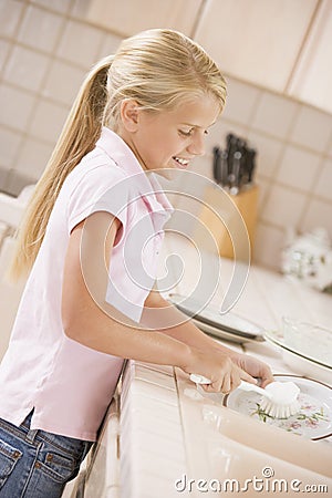 Young Girl Cleaning Dishes Stock Photo