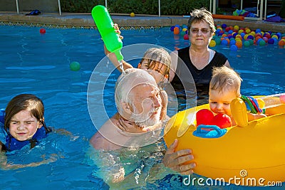 Young Girl Pours Water Over the Head of her Grandfather as Grand Stock Photo