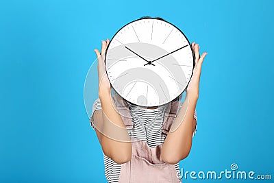 Young girl closing face by round clock Stock Photo